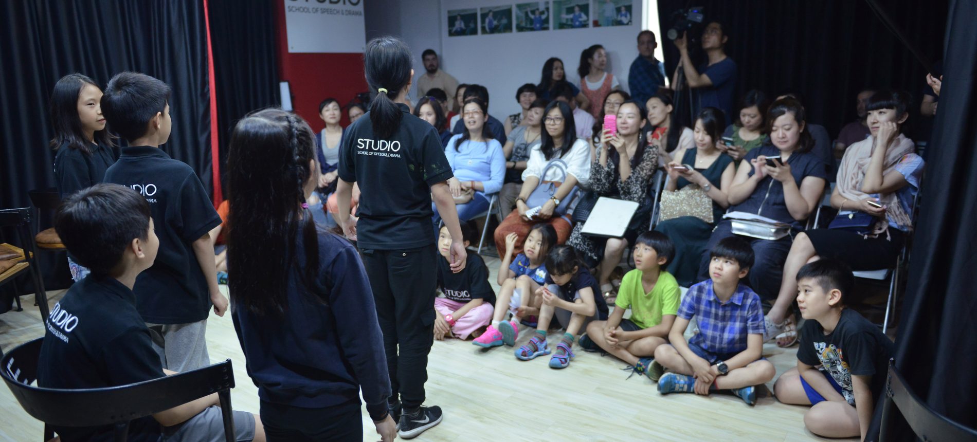 Families and students gathered for a performance in the Studio drama room